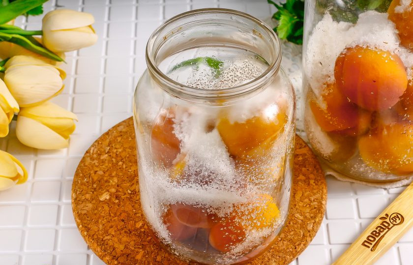 1. Этап. Компот из персиков с косточкой на зиму: Всыпьте в двухлитровую емкость 100 грамм сахарного песка, а в литровую 60 грамм сахара. На этом этапе можно добавить ванилин.