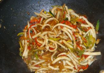 1. Этап. Кальмары в воке: Добавляем к овощам кальмары, соевый и фасолевый соусы, вино, пряности и сахар. Перемешиваем и тушим буквально минутку-полторы.