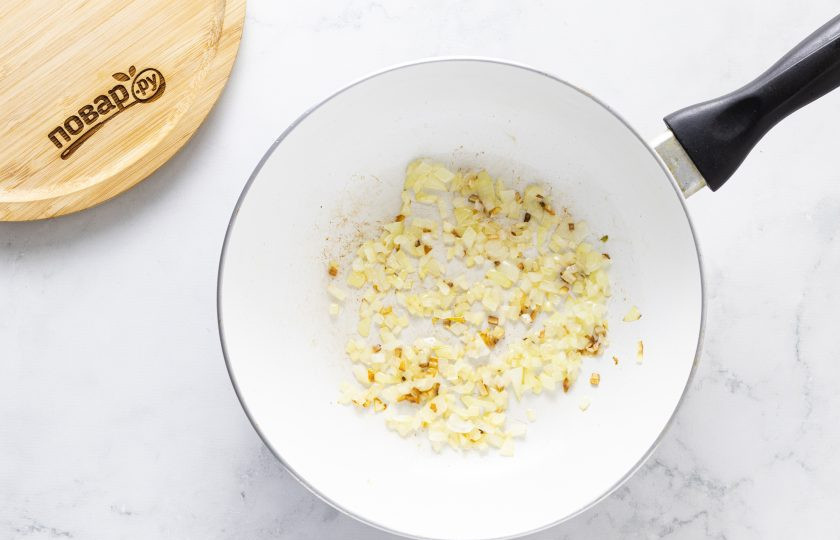 1. Этап. Фетучини с баклажанами в томатном соусе: Для томатного соуса разогрейте сковороду с растительным маслом. Пропустите чеснок через пресс и обжарьте его 20 секунд до раскрытия аромата. Затем добавьте мелко порубленный репчатый лук и жарьте 2-4 минуты до прозрачности.