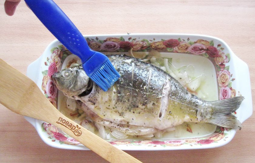 1. Этап. Карп в духовке на луковой подушке: Тщательно смажьте карпа яйцом и снова поставьте в духовку.