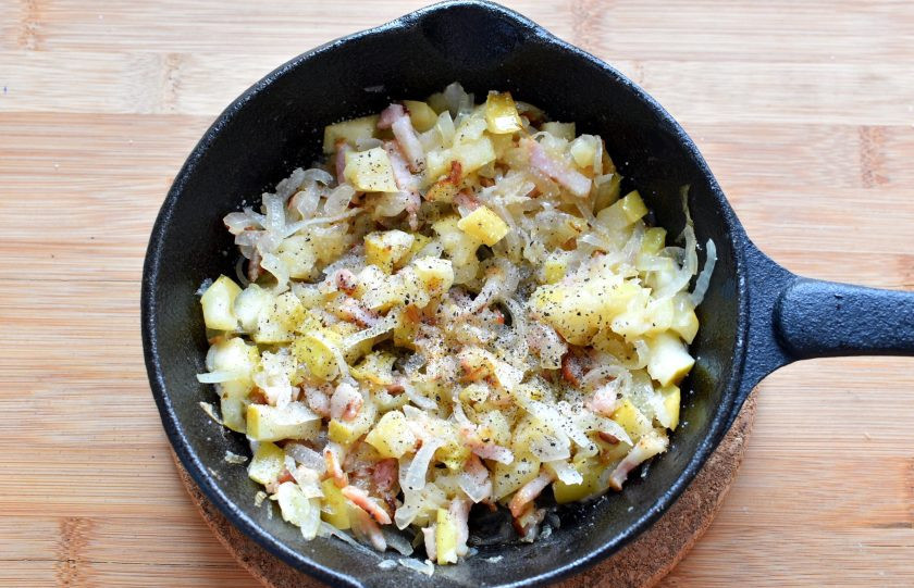 1. Этап. Свиные рулетики с яблоком: Нарежьте грудинку соломкой и поставьте обжариваться на средний огонь. Добавьте лук и жарьте, помешивая, до прозрачности лука. Добавьте нарезанные кубиками яблоки и прогрейте пару минут. Снимите с огня, немного посолите и поперчите по вкусу.