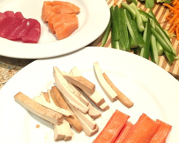 1. Этап. Роллы простые: 1. Нарежьте огурец тонкими полосками, морковь натрите на терке для моркови по-корейски или нарежьте очень тонкой соломкой, сыр и крабовые палочки нарежьте ломтиками. Небольшими кусочками нарежьте тунец и лосось, тонкими ломтиками нарежьте авокадо.