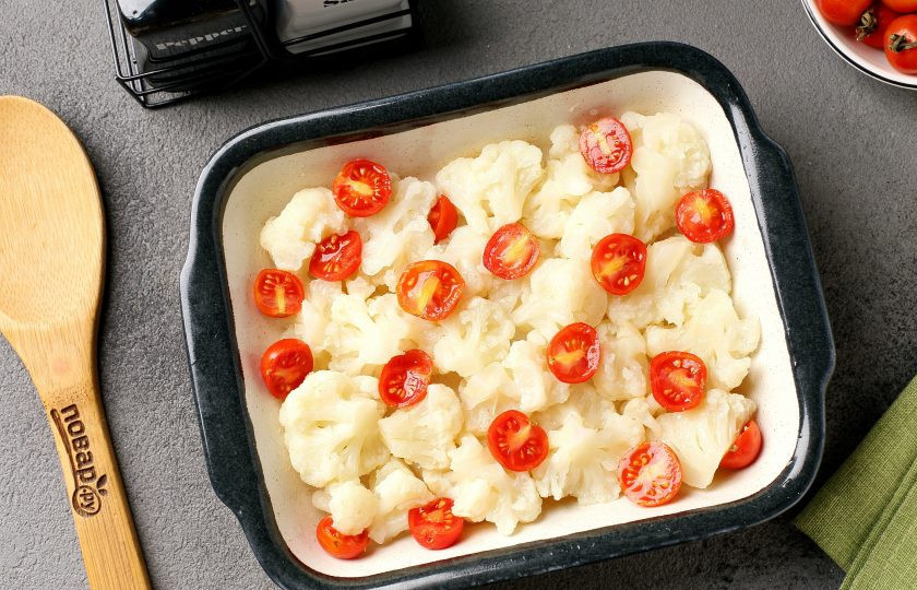 1. Этап. Запеканка из цветной капусты диетическая: Форму для запекания смажьте маслом. Выложите соцветия капусты и добавьте помидоры черри, разрезанные на 2 или 4 части, в зависимости от размера.