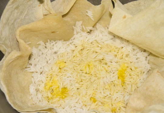 1. Этап. Плов азербайджанский с сухофруктами: По истечении получаса мы открываем крышку казана и заливаем в рис растопленное масло и приготовленную смесь шафрана и соли. Снова накрываем полотенцем и крышкой и еще на 20-30 минут ставим на медленный огонь.