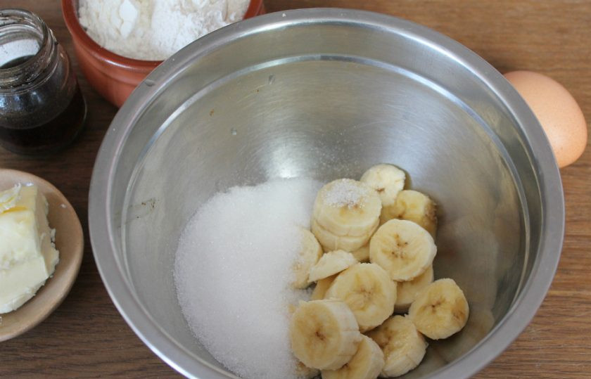 1. Этап. Песочное печенье с бананом: В миску насыпаем сахар и кладем порезанный на кусочки банан.