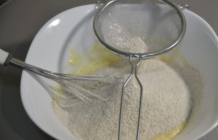 1. Этап. Перепечи с грибами: Просейте мучную смесь в миску к яично-сметанной смеси.