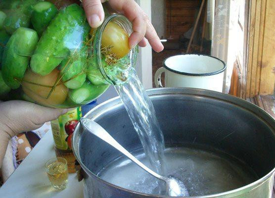 1. Этап. Консервированные огурцы: Далее слить воду из огурцов и помидоров в кастрюлю.