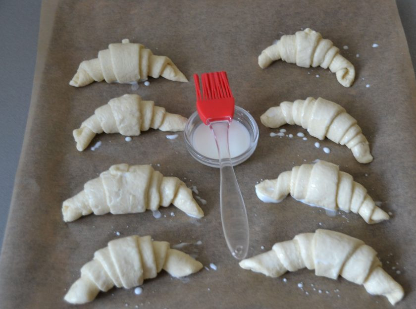 1. Этап. Круассаны с заварным кремом: Выложите круассаны на лист для выпечки, смажьте молоком.