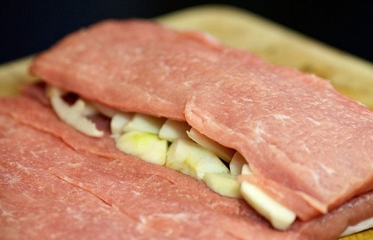 1. Этап. Рулет с сюрпризом: 7. Заверните сначала одну сторону свинины (яблоки должны оказаться накрытыми).