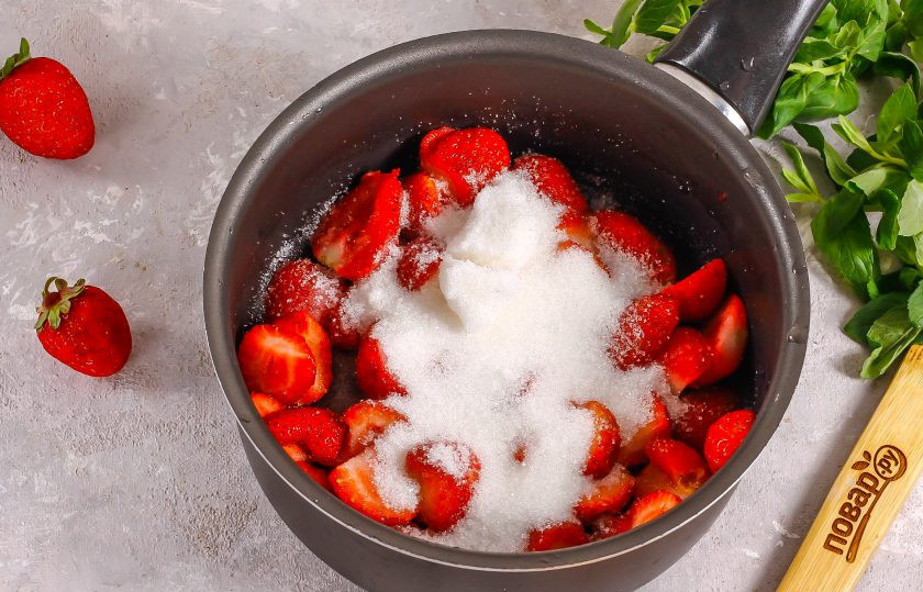 1. Этап. Клубничный чизкейк с творогом без выпечки: Оставшуюся клубнику очистите от хвостиков, разрежьте пополам и выложите в ковш или казан. Всыпьте оставшийся сахар и протомите примерно 5-7 минут на умеренном нагреве.