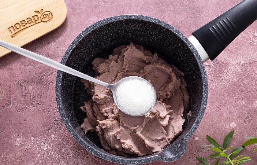 1. Этап. Бобовая паста Анко: Переложите пюре из фасоли обратно в кастрюлю. На среднем огне начните нагревать пюре. Добавьте половину сахара и перемешайте. Проварите, пока сахар не растворится и добавьте вторую половину.