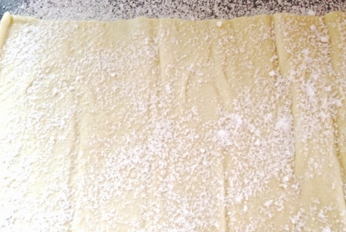 1. Этап. Мильфей со взбитыми сливками и малиной: 2. Раскатайте слоеное тесто, посыпьте его сахарной пудрой, отправьте цельный лист на 7 минут в разогретую до 220 градусов духовку, уменьшите температуру до 180 градусов и запекайте еще 15 минут.