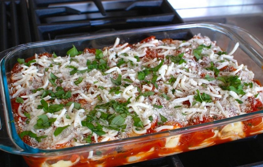 1. Этап. Маникотти из блинов с сырной начинкой: 10. Оставшийся пармезан и моцареллу натрите на терке и посыпьте ими блины, добавьте немного базилика.