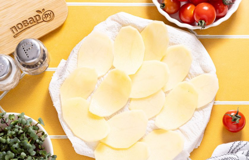 1. Этап. Чипсы из картошки в аэрогриле: Слейте воду, а слайсы картофеля обсушите с помощью бумажных полотенец.