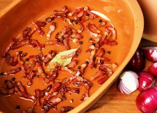 1. Этап. Петух в вине: Получившиеся шкварки от бекона выкладываем в форму для запекания.