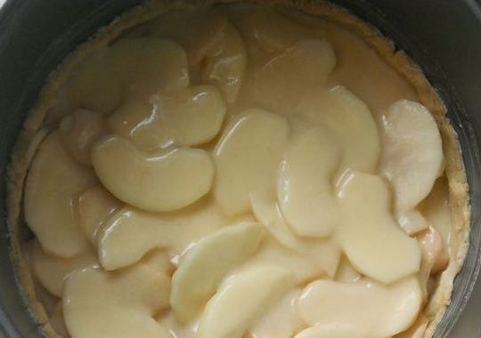 1. Этап. Цветаевский яблочный пирог в мультиварке: 4. Яблоки почистьте и нарежьте пластинками, как можно тоньше. Выложите их на тесто равномерно. Аккуратно вылейте поверх заливку.