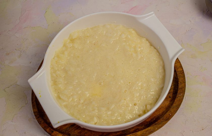 1. Этап. Рисовая запеканка с вишней: Выложите половину рисовой каши.