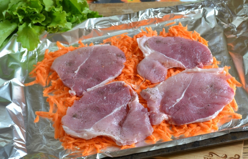 1. Этап. Мясо в духовке по-итальянски: Мясо посолите и поперчите с обеих сторон, выложите на морковную подушку.