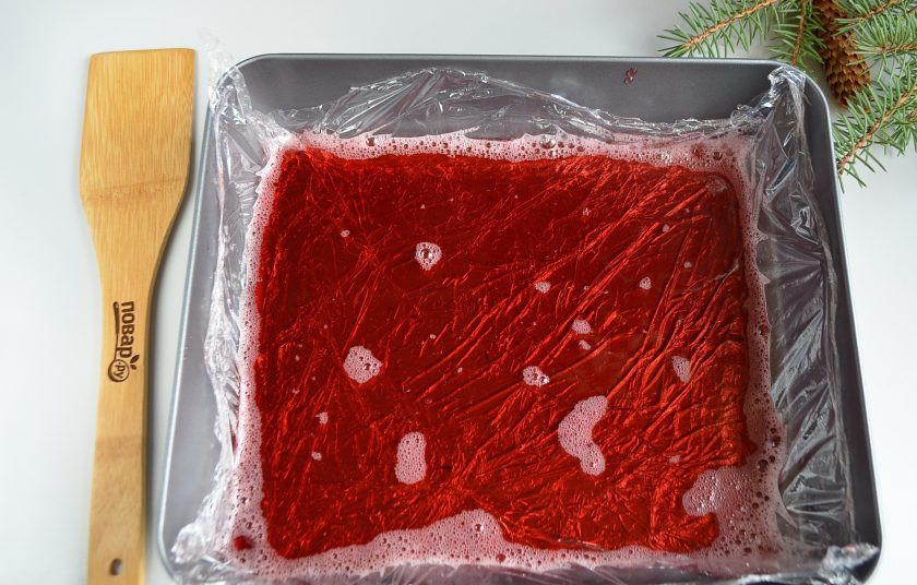 1. Этап. Куриный рулет в гранатовом желе: Застелите форму пищевой пленкой, перелейте желе и отправьте в холодильник застывать.