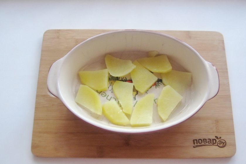 1. Этап. Запеканка с тефтелями: Картофель очистите, помойте и нарежьте пластиками толщиной 0,7-1 сантиметр. Проварите в кастрюле с подсоленной водой 7-8 минут. После выложите слой картофеля на дно формы для запекания.