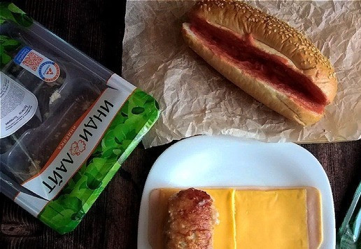 1. Этап. Хот-дог необычный: С края выкладываем обжаренную котлету и заворачиваем рулетиком. Булки разрезаем, недорезая с одной стороны. Обмазываем щедро внутри их кетчупом с майонезом.