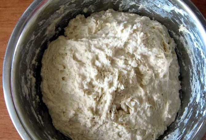 1. Этап. Вареники на кефире: Подсыпаем в тесто муку небольшими порциями, пока оно не станет достаточно густым.