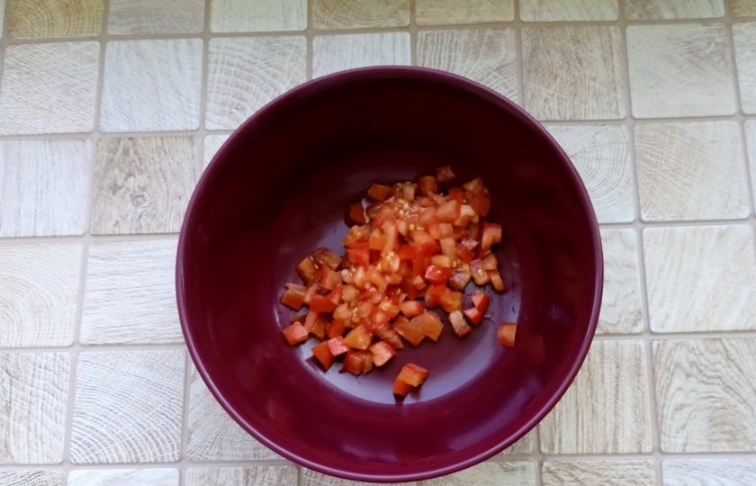 1. Этап. Салат Любимый с курицей и грибами: Помидоры вымойте, нарежьте мелким кубиком и выложите в миску.