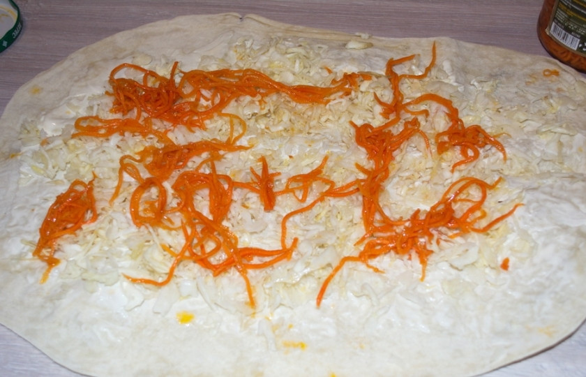1. Этап. Овощной рулет из лаваша: Морковь по-корейски отожмите от маринада и распределите сверху на капусте.