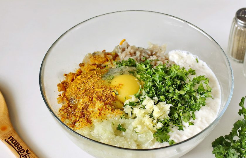 1. Этап. Рыбные котлеты в панировке: Добавьте к готовому фаршу яйцо, прокрученный через мясорубку лук, замоченный хлеб, измельченную зелень, пропущенный через пресс чеснок, соль, перец и специи по вкусу.