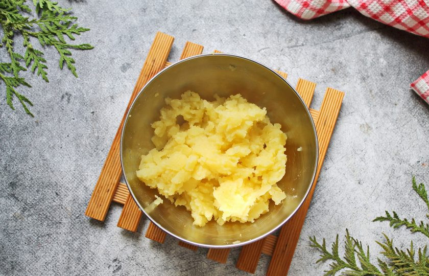 1. Этап. Запеченный картофель с беконом и сыром: Картофель который достали разомните вилкой, посолите и перемешайте.