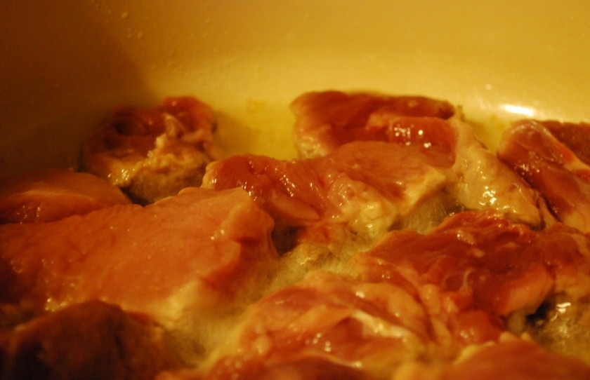 1. Этап. Жареная свинина с грибами: Мясо промойте, порежьте на кусочки и обжаривайте в масле.