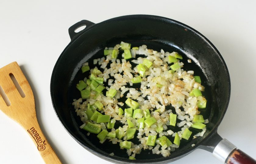 1. Этап. Баклажаны фаршированные гречкой: Затем добавьте нарезанный кубиками болгарский перец и измельченный ножом чеснок. Обжарьте все вместе до полной готовности.