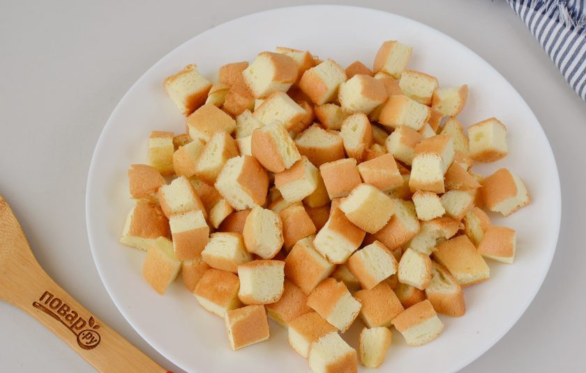 1. Этап. Желейный торт: Пока желатин настаивается, порежьте холодный бисквит кубиками.