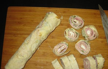 1. Этап. Рулет из лаваша с ветчиной и сыром: 11. После острым ножом нарежьте порционными кусочками и выложите на тарелку для подачи. Вниз можно положить листья салата.