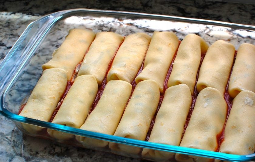 1. Этап. Маникотти из блинов с сырной начинкой: 5. Выложите все фаршированные блины в форму на соус.