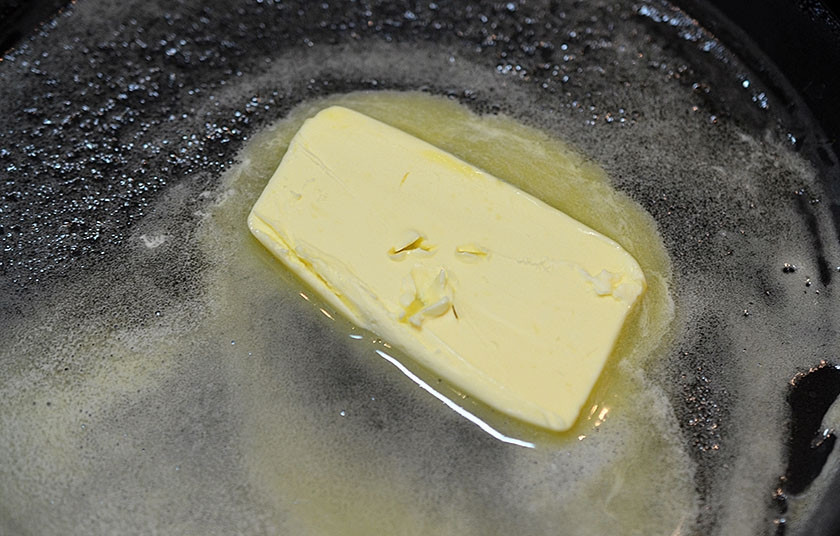 1. Этап. Омлетные роллы с зеленью и крабовыми палочками: 3. В сковороде растопите сливочное масло.