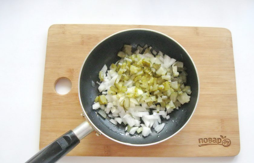 1. Этап. Солянка без копченостей: Соленый огурец натрите на терке или мелко нарежьте и добавьте к луку.