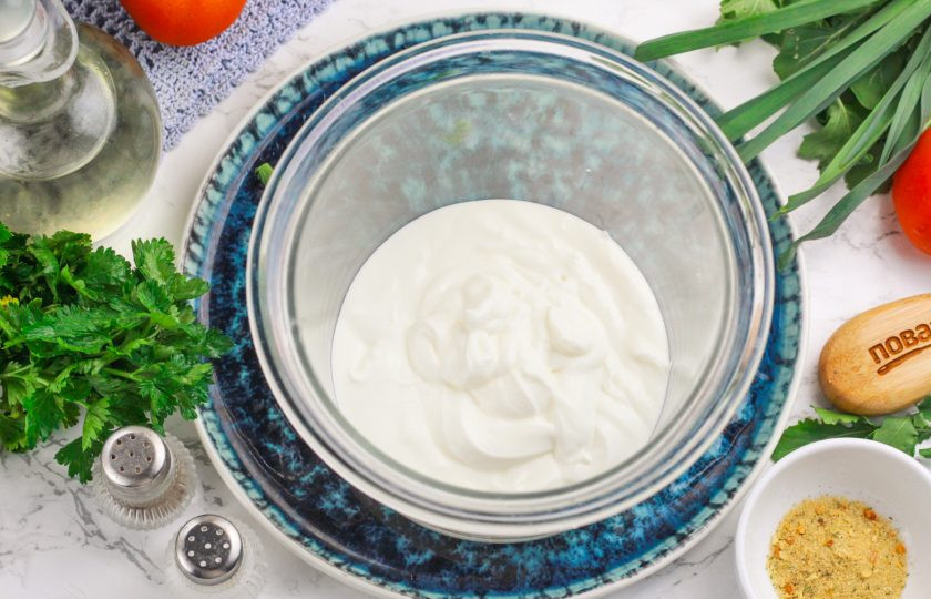 1. Этап. Белый соус со сметаной: Сметану выложите в чашу блендера или измельчителя. По желанию можно использовать продукт любой жирности и любого сорта, даже сметану из семечек (вегетарианскую).