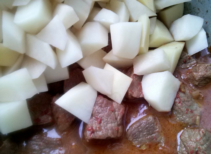 1. Этап. Гуляш по-венгерски с клецками: Очищенный картофель порежьте кубиками немного меньше мяса. Томаты, перец горький и сладкий нарежьте кусочками. Все овощи выложите к мясу, добавьте томатную пасту, налейте бульон, так чтобы он на палец не покрывал гуляш. Посолите по вкусу и тушите при закрытой крышке до готовности картофеля.