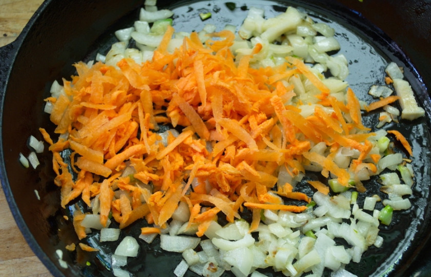 1. Этап. Рыбный суп с картофелем: К обжаренному луку добавьте морковь. Тушите все вместе. Помешивайте.