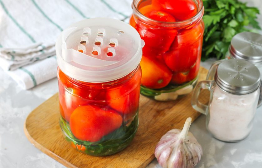 1. Этап. Помидоры с семенами горчицы на зиму: В казан или кастрюлю всыпьте соль, смените крышки на банках и слейте жидкость в кастрюлю. Прогрейте рассол до кипения, выключите нагрев и влейте уксус.