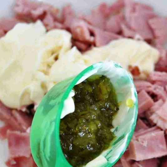 1. Этап. Салат с ветчиной: Маринованные огурцы разминаем в ступке или мелко-мелко нарезаем, добавляем к ветчине.