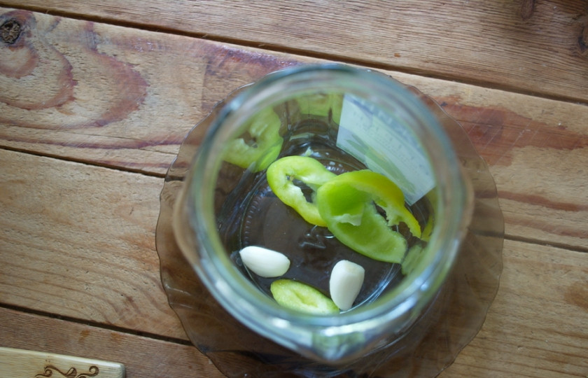 1. Этап. Консервированные помидоры на зиму: В стерильную банку выкладываем базилик, травки, эстрагон, несколько зубчиков чеснока.