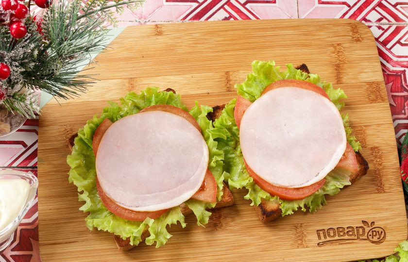 1. Этап. Бутерброды Змейка для праздничного стола: На помидоры выложите карбонад или любые другие колбасные изделия. Теперь при помощи майонеза нарисуйте змейку.