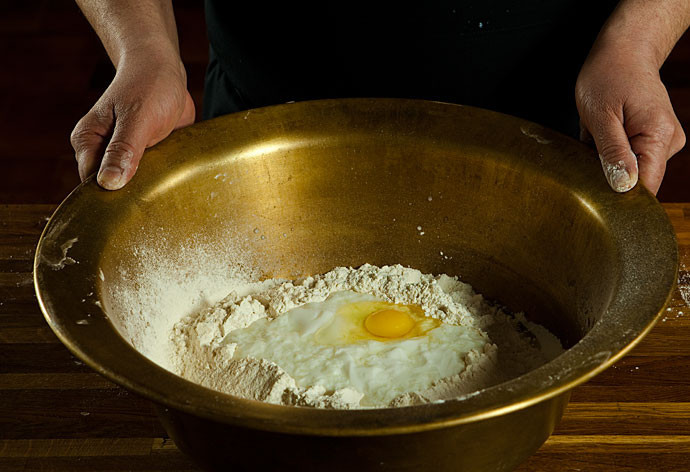 1. Этап. Тесто из катыка: Просеиваем в миску муку, вбиваем одно яйцо и заливаем катык, воду. Добавляем соль, сахар и дрожжи.