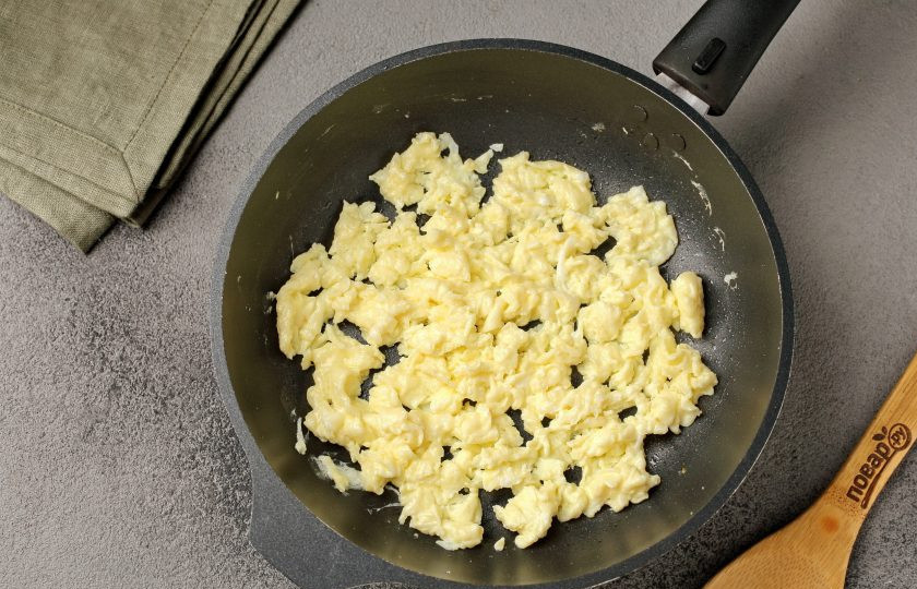 1. Этап. Ролтон с яйцом на сковороде: В сковороде растопите кусочек сливочного масла, влейте взбитое яйцо и быстрыми движениями перемешайте его лопаткой, чтобы получились воздушные яичные хлопья.