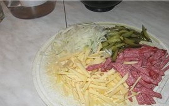 1. Этап. Салат Мюнхенский: Соломкой нарежьте колбасу, сыр и маринованные огурцы. Репчатый лук нарежьте тонкими полукольцами.