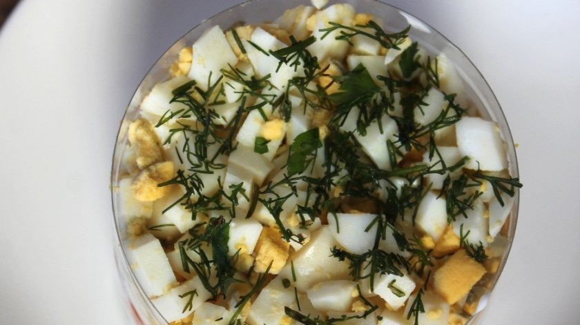 1. Этап. Слоеный салат с солеными огурцами: В конце выложите кусочки отваренных яиц и зелень.