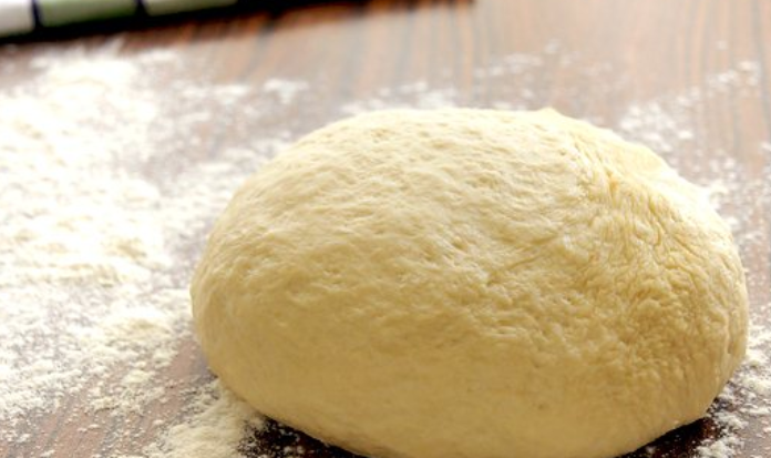 1. Этап. Бухарская самса: Присыпаем стол мукой, выкладываем на него тесто — и продолжаем замес руками.