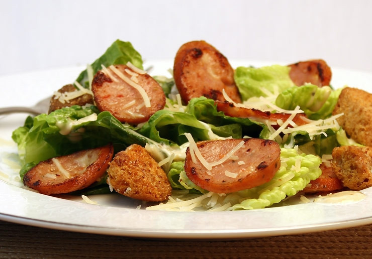 1. Этап. Салат Цезарь с колбасой: Выложить на салатные листья колбасу и крутоны, полить остатками соуса и посыпать тертым пармезаном. Салат 